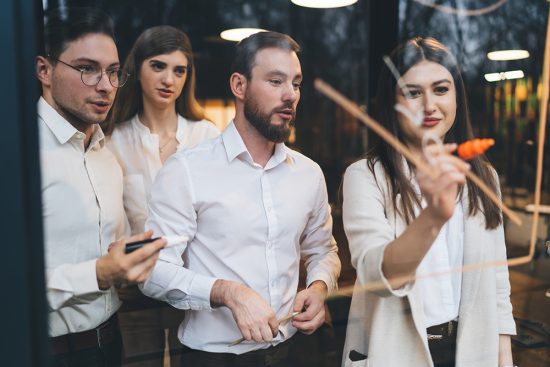 Group Of Coworkers Discussing Strategy Plans In Conference Hall